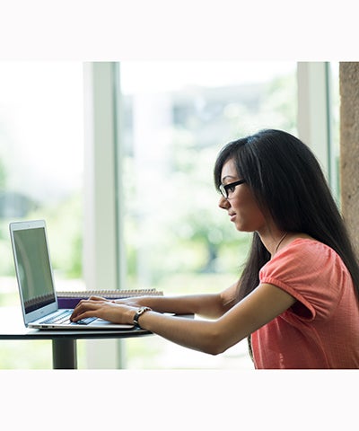 Woman Writing on Laptop