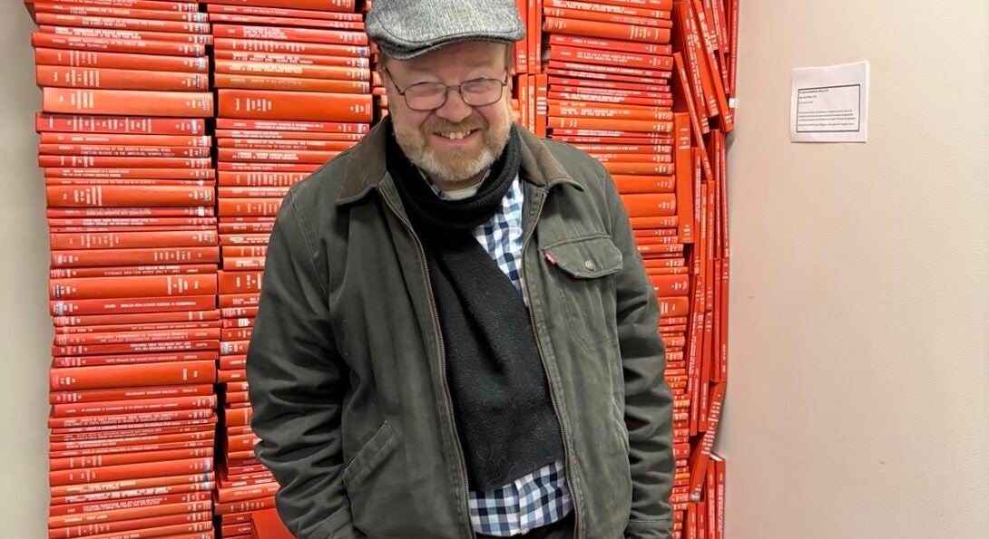 Jim dwarfed by stacks of theses and dissertations.