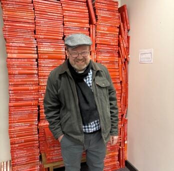 Jim dwarfed by stacks of theses and dissertations.
                  