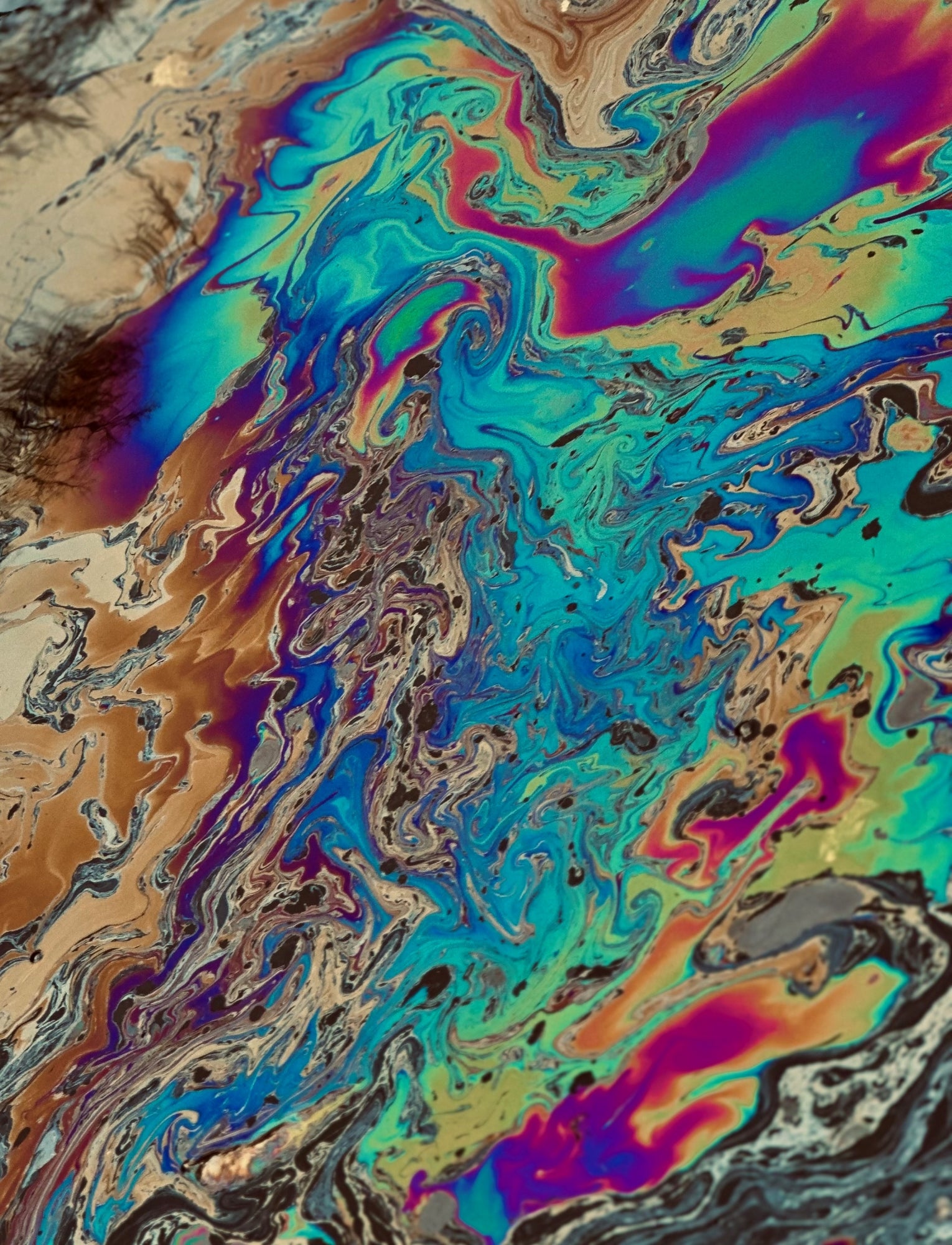 Chemicals form a rainbow colored shimmer on a water surface.
